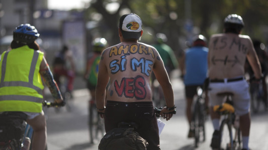 A cyclist, with a message written on his back that reads in Spanish, "Now you see me," takes part in a "naked" bike ride event in Caracas, Venezuela, Saturday, June 13, 2015. The clothing-optional campaign, "Let's see if you see me" draws attention to cyclist safety. (AP Photo/Ariana Cubillos)