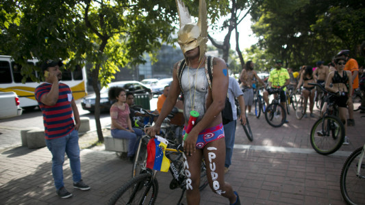 A masked cyclist takes part in a "naked bike ride event" in Caracas, Venezuela, Saturday, June 13, 2015. The clothing-optional campaign, "Let's see if you see me" draws attention to cyclist safety. (AP Photo/Ariana Cubillos)